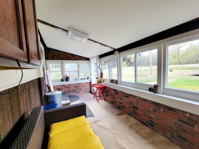 sunroom / solarium featuring a healthy amount of sunlight and lofted ceiling