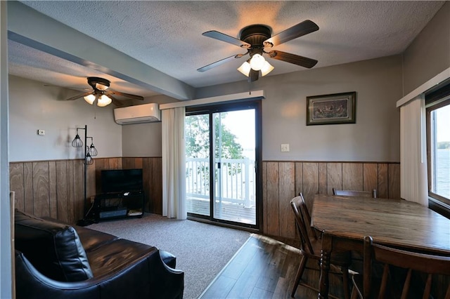 living room with ceiling fan, hardwood / wood-style flooring, a textured ceiling, and an AC wall unit