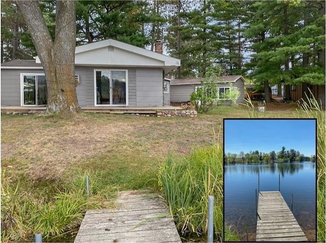 back of property featuring a lawn and a water view