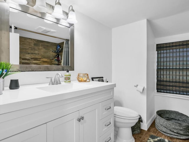 bathroom with hardwood / wood-style flooring, toilet, and vanity