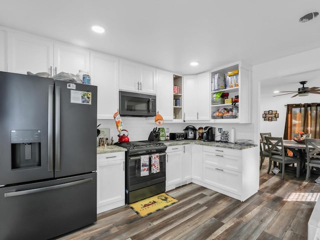 kitchen featuring dark wood-type flooring, black appliances, white cabinetry, and light stone countertops