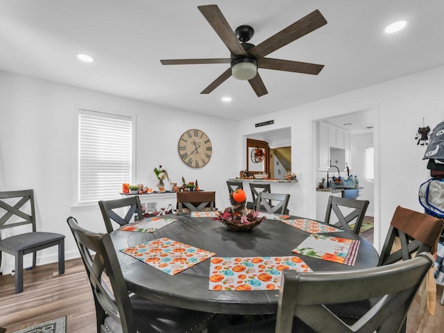 dining area with light hardwood / wood-style floors and ceiling fan