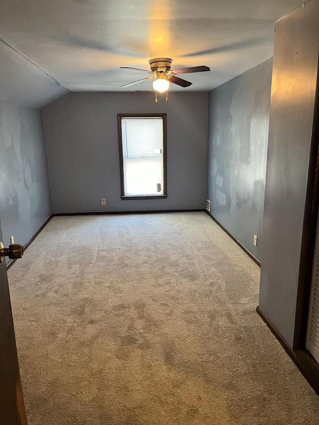 additional living space with ceiling fan, vaulted ceiling, and light colored carpet