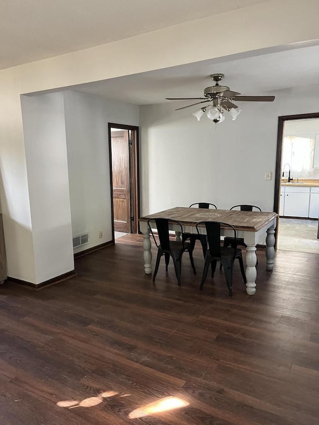 dining area with ceiling fan, dark wood-type flooring, and sink