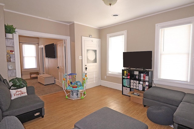 living room featuring hardwood / wood-style flooring, plenty of natural light, and crown molding