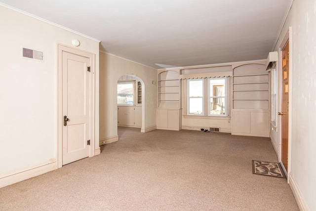 carpeted spare room featuring crown molding