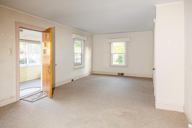 carpeted empty room with plenty of natural light and ornamental molding