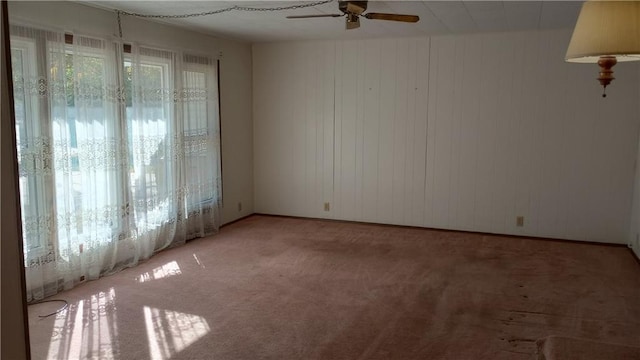 carpeted spare room featuring ceiling fan