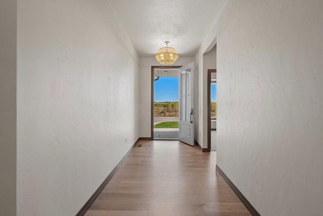 doorway to outside with hardwood / wood-style floors and an inviting chandelier