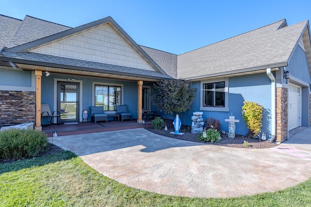 view of front of property with a garage, a front lawn, and covered porch