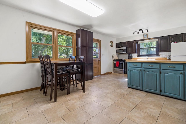 kitchen with a wealth of natural light, appliances with stainless steel finishes, and butcher block counters