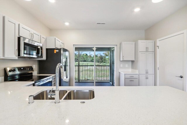 kitchen featuring stainless steel appliances, sink, and white cabinetry