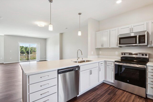 kitchen featuring dark hardwood / wood-style floors, stainless steel appliances, sink, kitchen peninsula, and white cabinetry