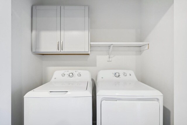 laundry room featuring cabinets and washer and dryer