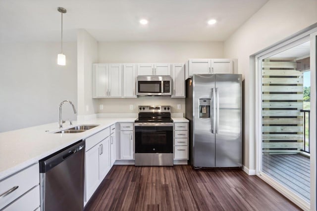 kitchen with dark wood-style floors, light countertops, white cabinetry, stainless steel appliances, and a sink