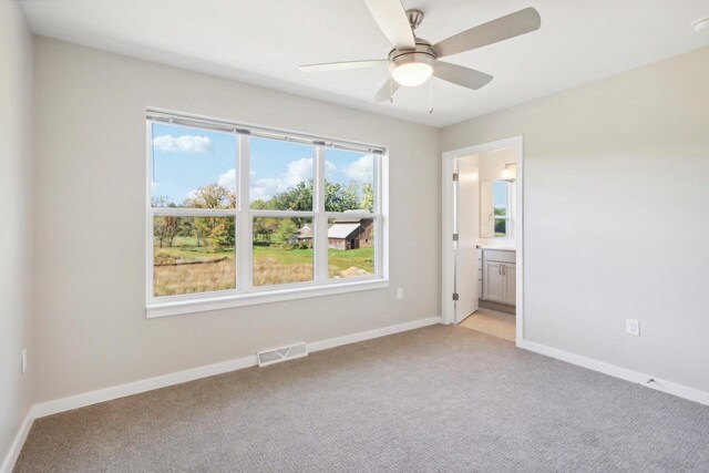 spare room featuring ceiling fan and light carpet