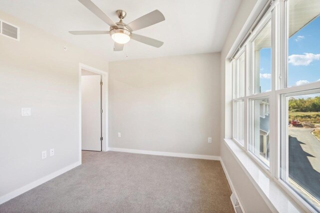 spare room with ceiling fan and light carpet