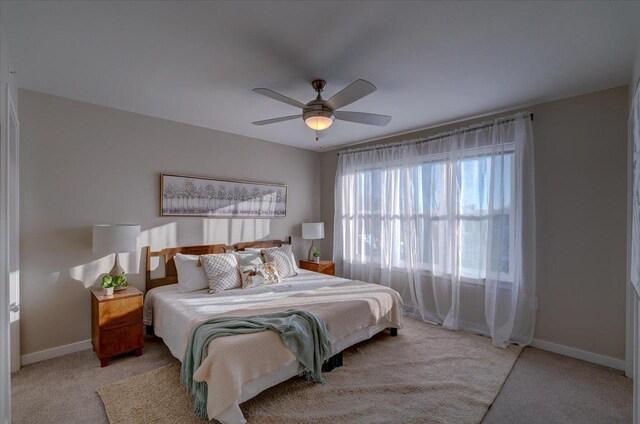 bedroom featuring baseboards, a ceiling fan, and light colored carpet