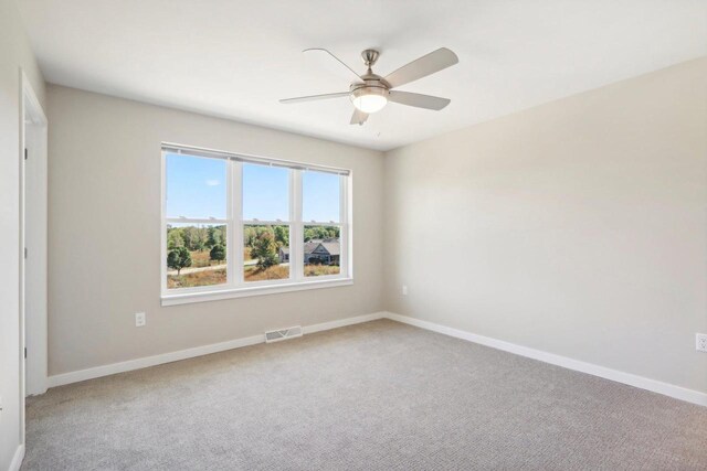 carpeted empty room featuring ceiling fan