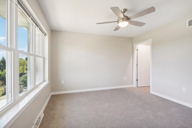 carpeted spare room with ceiling fan