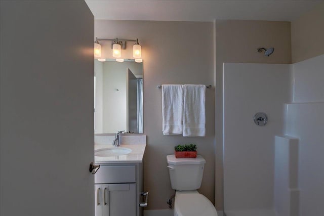 full bathroom with a shower stall, vanity, and toilet