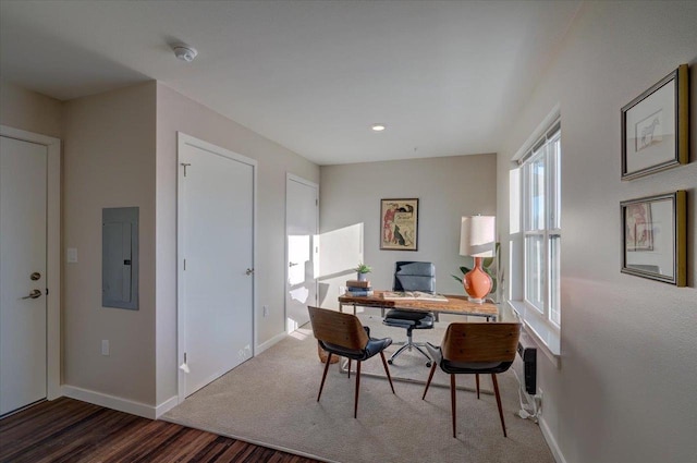 office space with baseboards and electric panel