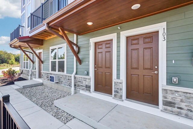 view of exterior entry with a porch and a balcony