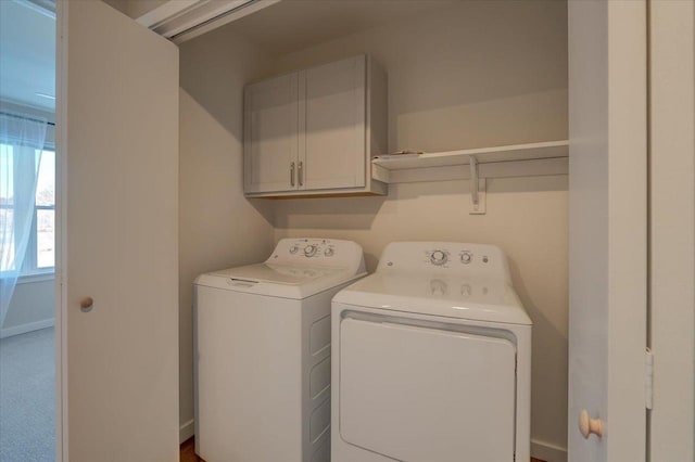 washroom with separate washer and dryer, baseboards, and cabinet space