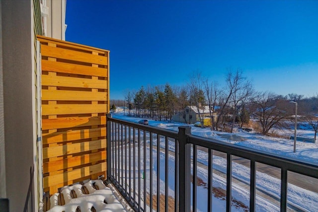 view of snow covered back of property
