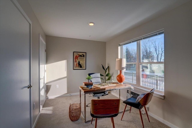 home office featuring baseboards and light carpet