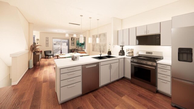 kitchen featuring pendant lighting, sink, kitchen peninsula, dark wood-type flooring, and stainless steel appliances