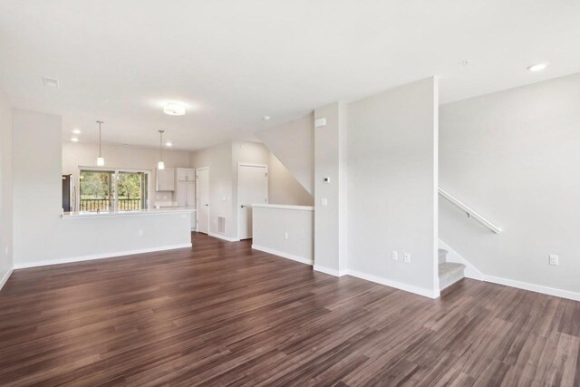 unfurnished living room with dark wood-type flooring