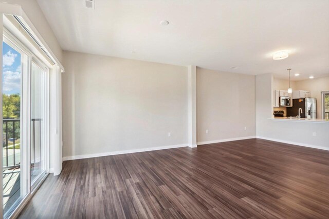 unfurnished living room with dark hardwood / wood-style flooring and sink