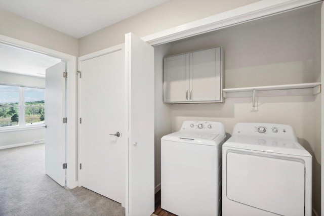 laundry area with light carpet, cabinet space, and independent washer and dryer