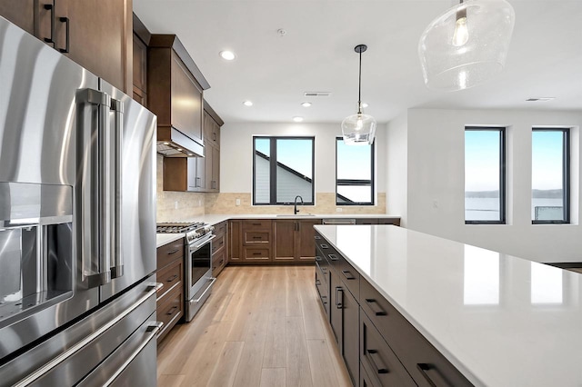 kitchen with a sink, visible vents, light countertops, appliances with stainless steel finishes, and decorative backsplash