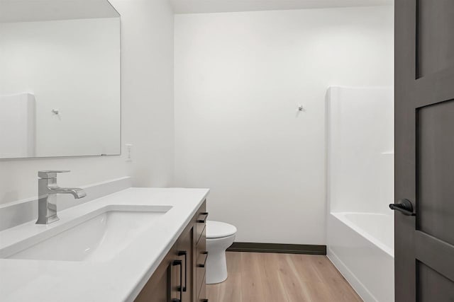 full bath featuring baseboards, vanity, toilet, and wood finished floors