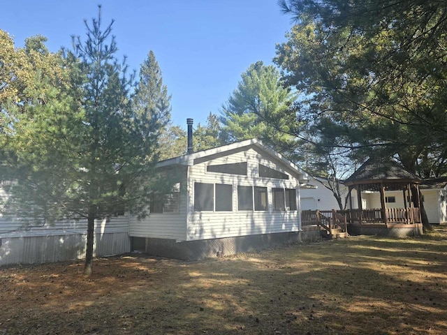 view of property exterior with a gazebo and a lawn