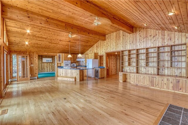 6874N Victory Heights Cir, Stone Lake, WI 54876 - unfurnished living room featuring wooden walls, light wood-type flooring, wooden ceiling with exposed beams, and high vaulted ceiling