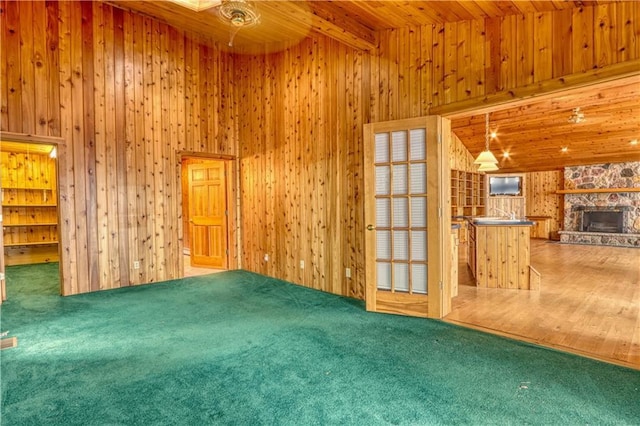 6874N Victory Heights Cir, Stone Lake, WI 54876 - unfurnished living room with wood walls, carpet, a fireplace, and wooden ceiling with exposed beams