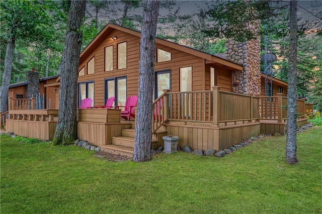 6874N Victory Heights Cir, Stone Lake, WI 54876 - rear view of house with a chimney, a yard, and a deck