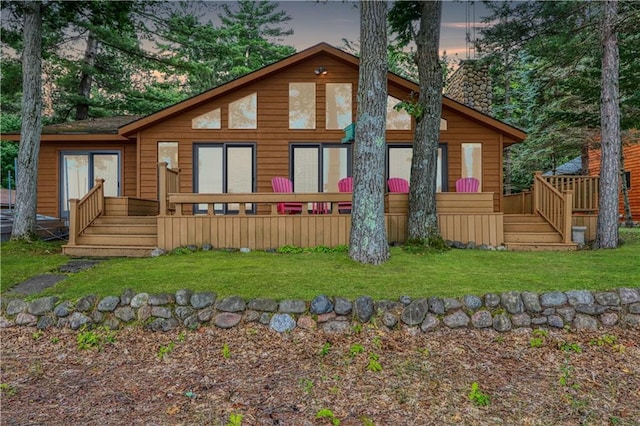 6874N Victory Heights Cir, Stone Lake, WI 54876 - back of property with a chimney, a wooden deck, and a lawn