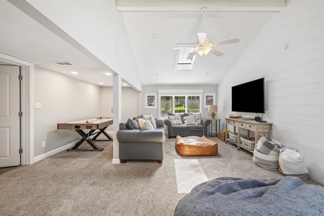 carpeted living room with high vaulted ceiling, beam ceiling, a skylight, and ceiling fan