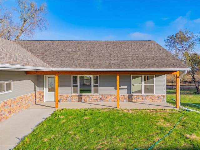 425 Mourning Dove Ct, Arena, WI 53503 - back of house with roof with shingles, a patio area, stone siding, and a lawn