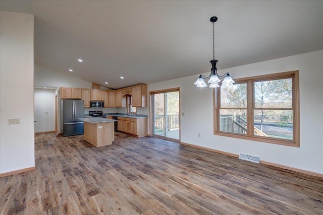 425 Mourning Dove Ct, Arena, WI 53503 - kitchen featuring appliances with stainless steel finishes, light brown cabinets, light wood-type flooring, vaulted ceiling, and a chandelier