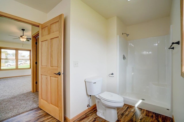 bathroom featuring walk in shower, hardwood / wood-style flooring, and toilet