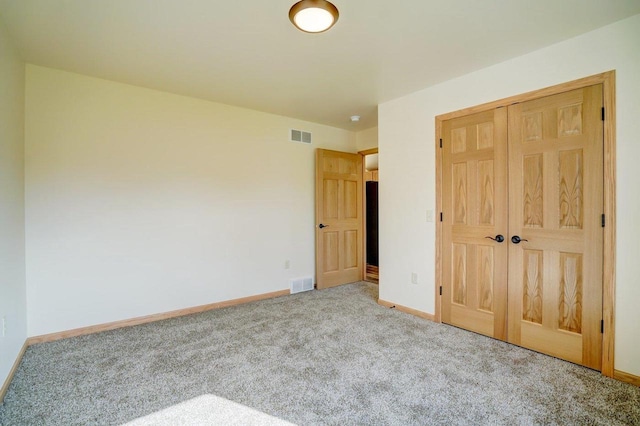 unfurnished bedroom with a closet and light carpet