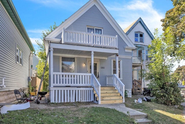 view of front facade featuring a balcony and a front lawn