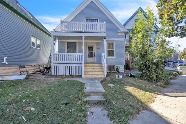 view of front of property with a front yard and a balcony