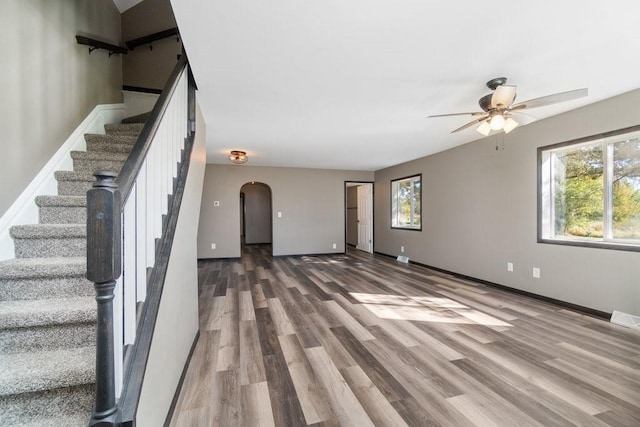 unfurnished living room with ceiling fan, hardwood / wood-style flooring, and a wealth of natural light