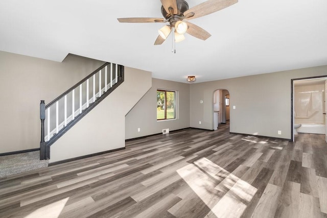 unfurnished living room featuring dark hardwood / wood-style flooring and ceiling fan